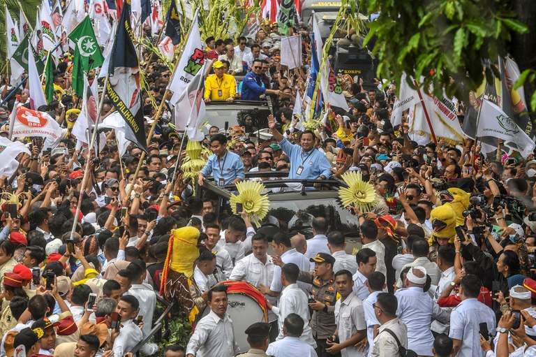 Menteri Pertahanan dan calon presiden Indonesia, Prabowo Subianto, dan pasangannya, Gibran Rakabuming Raka (keduanya mengenakan atasan berwarna biru) menyapa para pendukungnya saat tiba di Komisi Pemilihan Umum di Jakarta, 25 Oktober 2023, untuk secara resmi mendaftarkan keikutsertaan mereka sebagai calon presiden dan wakil presiden dalam pemilu tahun depan. [Muhammad Adimaja/Antara Foto/via Reuters]