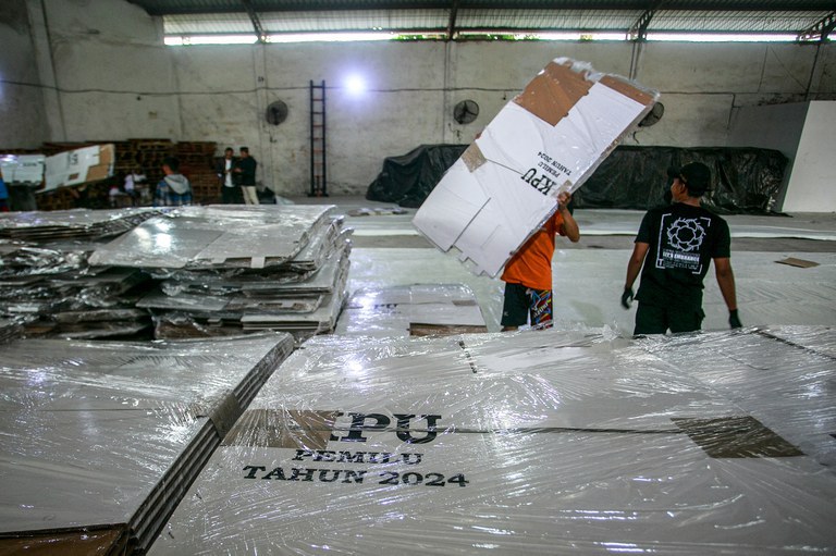 Para pekerja menata kotak suara yang dilipat di gudang KPU di Yogyakarta, 3 November 2023. [Devi Rahman/AFP]