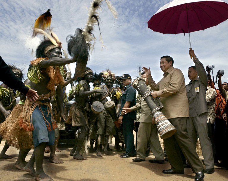 Presiden Indonesia saat itu Susilo Bambang Yudhoyono (kanan) menabuh genderang tradisional saat ia dan warga Papua merayakan musim panen di Merauke, Papua, 5 April 2006. [Dudi Anung/Istana Presiden/Handout via AFP]