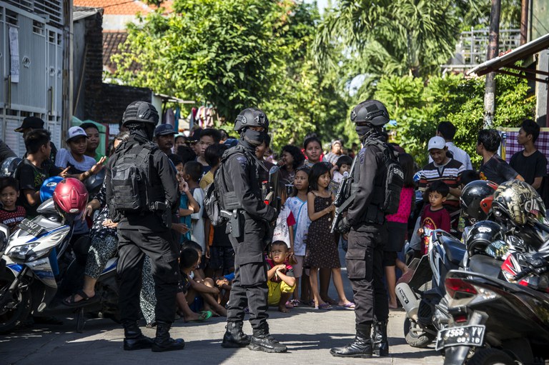 Anggota Densus 88 mengepung jalan saat mereka menggeledah sebuah rumah menyusul penangkapan seorang laki-laki yang dicurigai memiliki hubungan dengan kelompok militan Negara Islam (ISIS), di Surabaya, Jawa Timur, 19 Juni 2017. [Juni Kriswanto/AFP]
