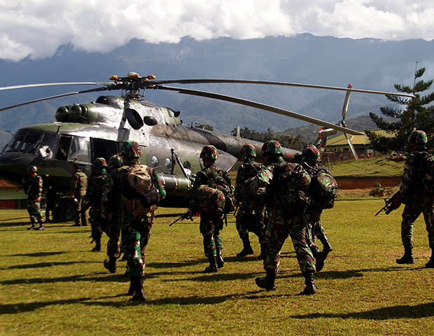 Tentara Indonesia membawa senjata mereka ketika berjalan menuju helikopter untuk terbang ke kecamatan Nduga, Wamena, Papua, tanggal 5 Desember 2018. (Antara Foto/Iwan Adisaputra via Reuters) 