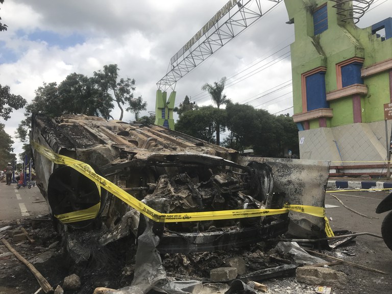 Dalam foto tertanggal 2 Oktober 2022 ini, tampak sebuah kendaraan pribadi dibakar suporter Arema FC Malang di Stadion Kanjuruhan Malang, Jawa Timur, usai kekalahan tim mereka dalam pertandingan melawan Tim Persebaya Surabaya pada malam sebelumnya. [Eko Widianto/BenarNews]