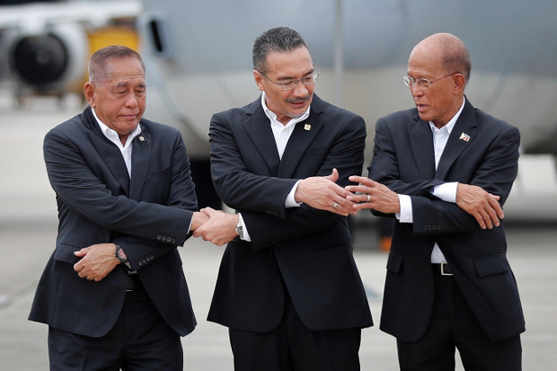 Menteri Pertahanan RI Ryamizard Ryacudu (kiri) bergabung dengan rekan-rekannya dari Malaysia, Hishammuddin Hussein (tengah), dan Filipina, Delfin Lorenzana, untuk foto bersama setelah peluncuran patroli udara bersama di pangkalan udara militer Subang di Petaling Jaya, Malaysia, 12 Oktober 2017. [AP]