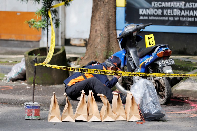 Seorang anggota polisi dari unit identifikasi di bawah Badan Reserse Kriminal Polri mencari dan mengumpulkan barang bukti setelah terjadinya bom bunuh diri di Markas Kepolisian Sektor Astana Anyar, Bandung, Jawa Barat, 7 Desember 2022. [Willy Kurniawan/Reuters]