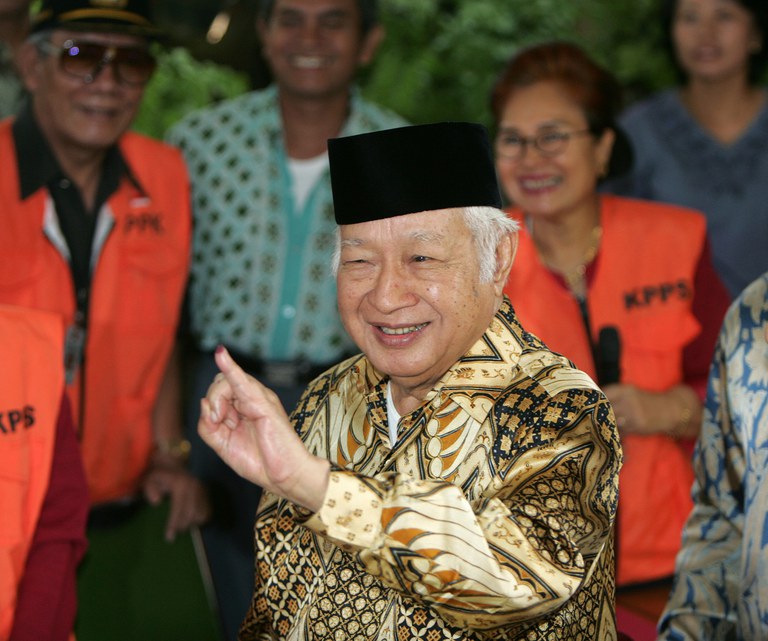 Mantan Presiden Indonesia Suharto menunjukkan jarinya yang telah ditandai tinta setelah memberikan suara dalam pemilihan presiden di Jakarta, 20 September 2004. [Enny Nuraheni/Reuters]