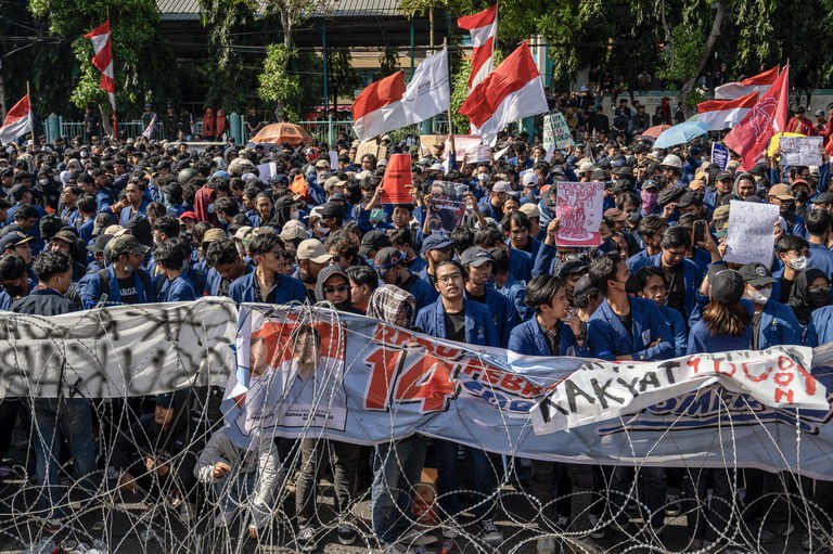 Orang-orang memegang poster dalam aksi protes menentang upaya untuk membatalkan keputusan Mahkamah Konstitusi yang mengubah aturan kelayakan kandidat dalam pemilihan kepala daerah, di depan gedung DPRD Provinsi Jawa Timur, Surabaya, 23 Agustus 2024. [Juni Kriswanto/AFP]