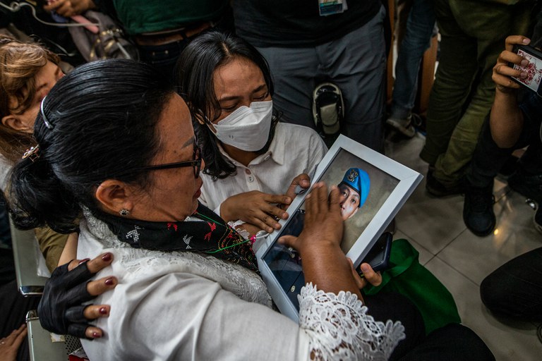Rosti Simanjuntak (kiri), ibu mendiang Brigadir Nopriansyah Yosua Hutabarat, memegang foto anaknya setelah mantan Kepala Divisi Propam Ferdy Sambo dijatuhi hukuman mati dalam sidang pembacaan vonis di Pengadilan Negeri Jakarta Selatan, 13 Februari 2023. [Aditya Aji/AFP]