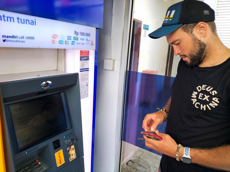 Warga Rusia, Konstantin Ivanov, berusaha untuk menarik uang kas dari kartu yang dikeluarkan oleh bank di Rusia di sebuah ATM di Bali, 8 Maret 2022. [Reuters]
