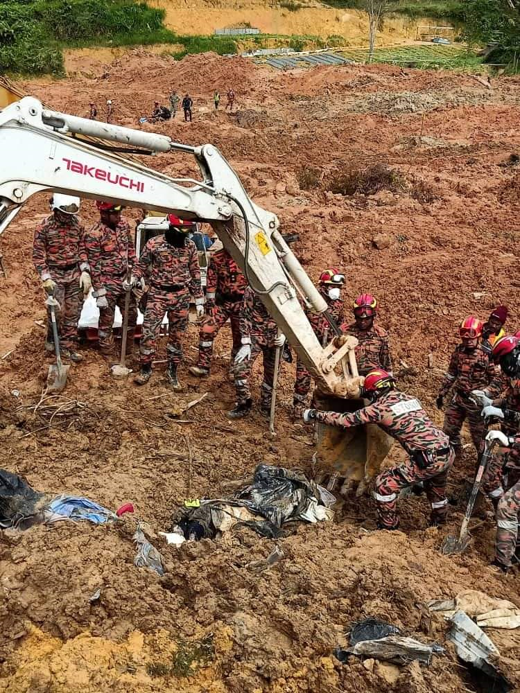 Anggota Jabatan Bomba dan Penyelamat Malaysia menggunakan jengkaut untuk mengeluarkan mayat mangsa yang dijumpai di lokasi tanah runtuh di Father’s Organic Farm, Batang Kali, Gohtong Jaya di Selangor pada 21 Di 2022. [Gambar Ihsan Jabatan Bomba dan Penyelamat Malaysia]