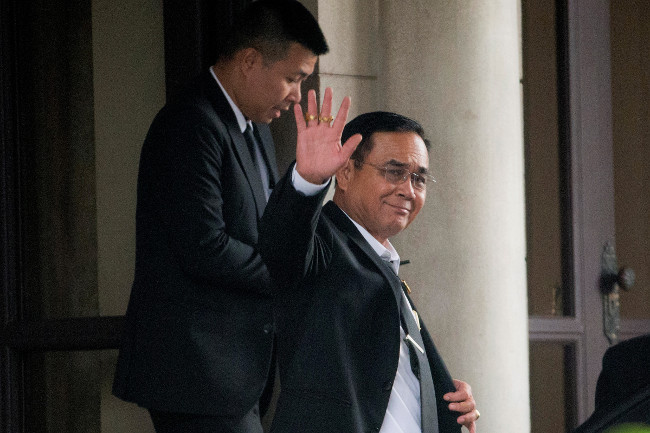 พลเอกประยุทธ์ จันทร์โอชา นายกรัฐมนตรี โบกมือให้สื่อมวลชนที่มารอทำข่าว ก่อนออกจากทำเนียบรัฐบาล กรุงเทพฯ ตอนเย็นวันพุธที่ 5 มิถุนายน 2562 (เอพี)